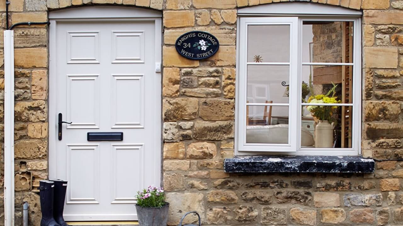 Anglian vs Everest. Anglian Cream wooden casement window cottage bars matching front door