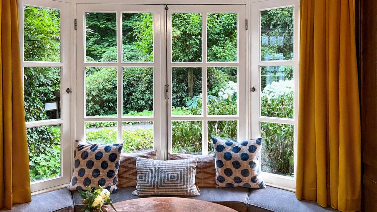window seat in bay window with orange curtains