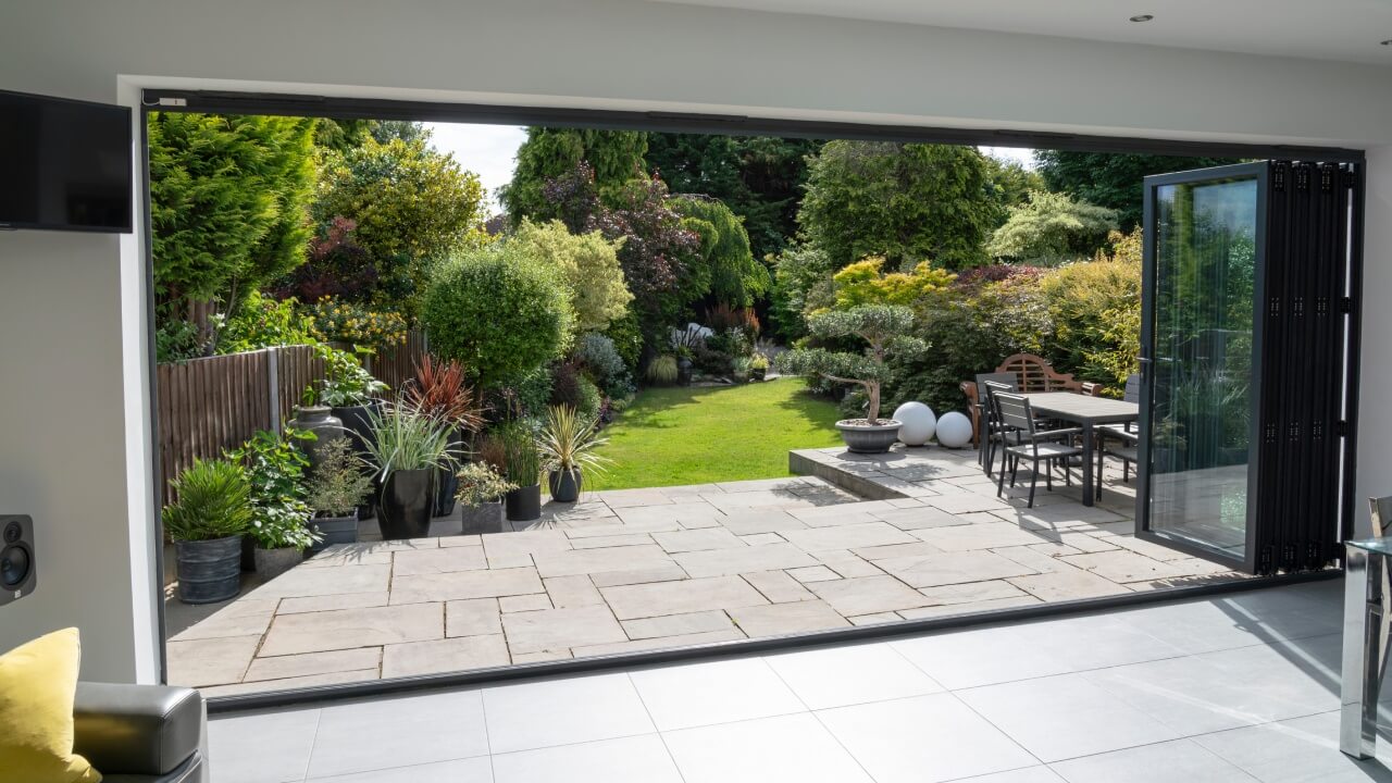 Doors and windows. Beautiful garden and patio in summer as seen through large bifold doors.