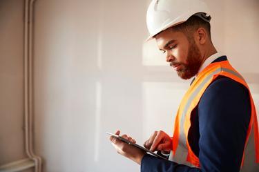 Builder assessing plans on site
