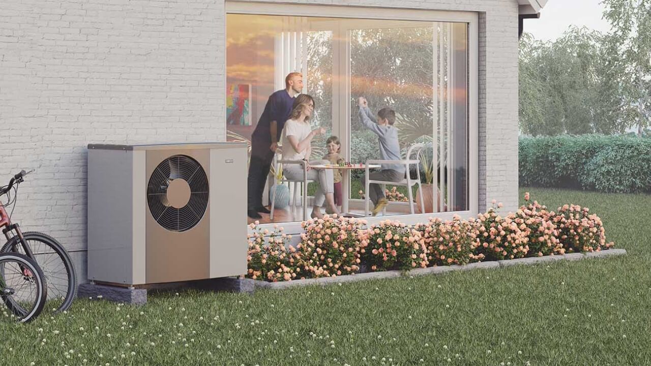A Nibe F2040 air source heat pump installed outside a house with a family inside.