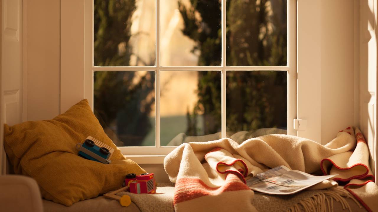 window seat with toys around and home security entry sensor on sash window