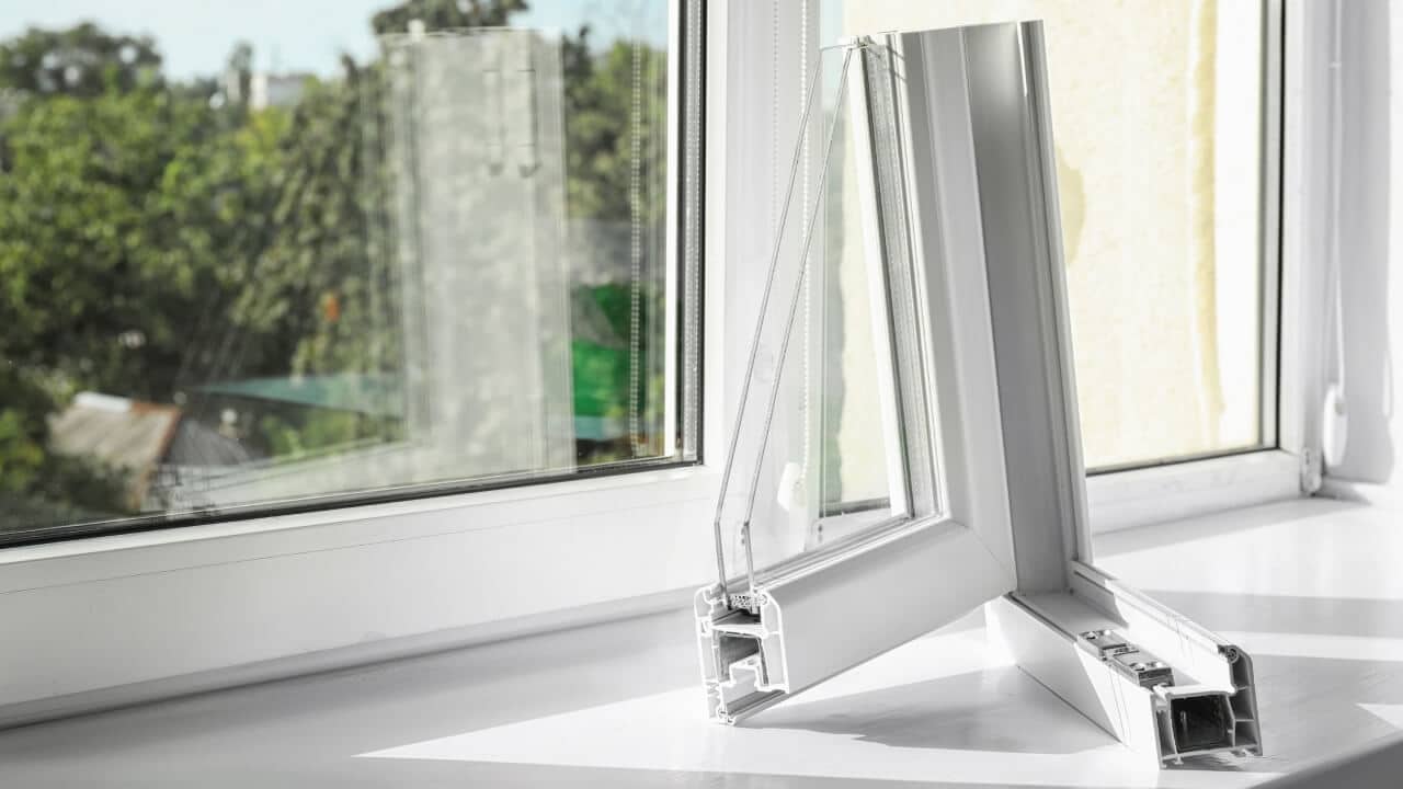 A cross section of a white uPVC window with double glazing sitting on a window frame to show how uPVC windows are made..